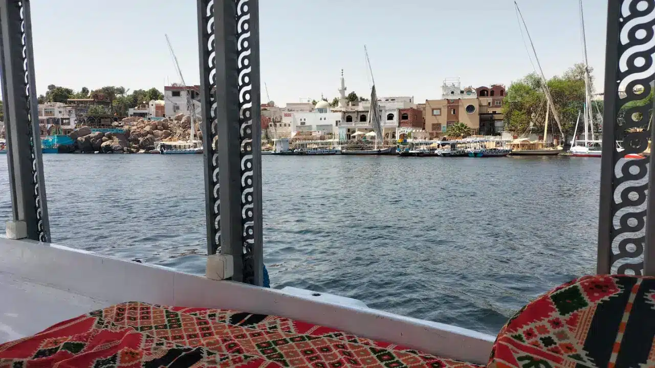View from a felucca boat of a colorful Nubian village along the Nile River in Aswan