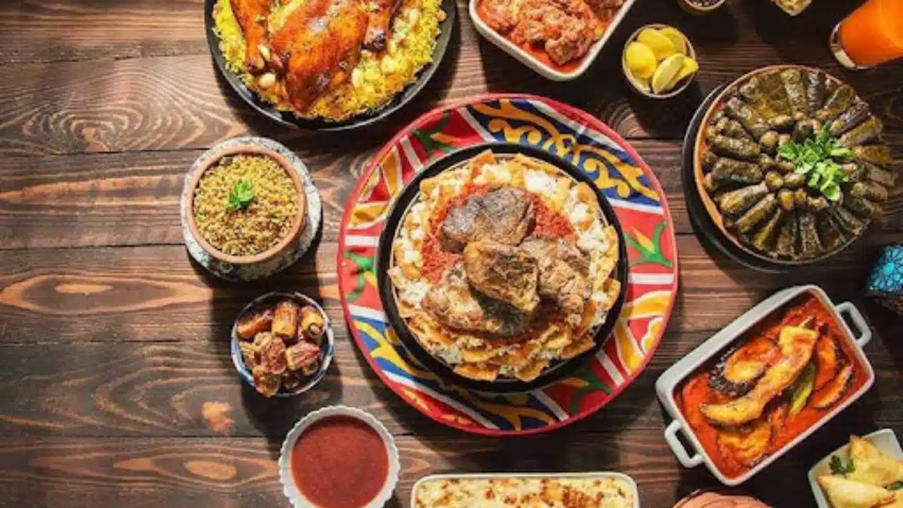 Table with traditional Egyptian dishes including molokhia, mahshi, roasted meat, dates, rice, and feteer.