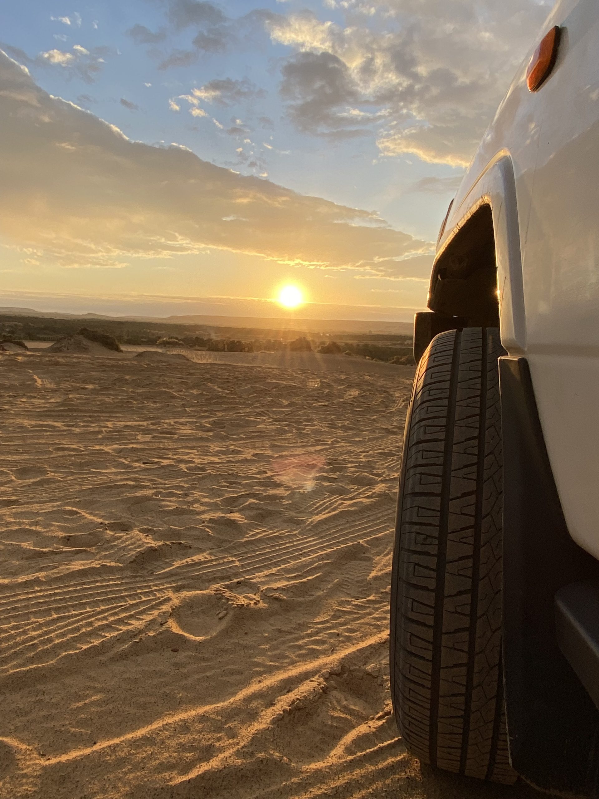 4x4 vehicle tire on sand dunes at sunset in Egypt’s Western Desert