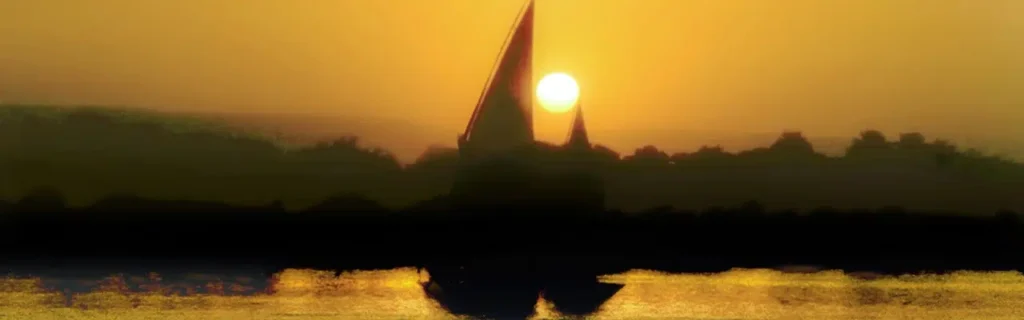 Traditional Egyptian felucca sailing on the Nile at sunset near Aswan with golden light reflecting on the water