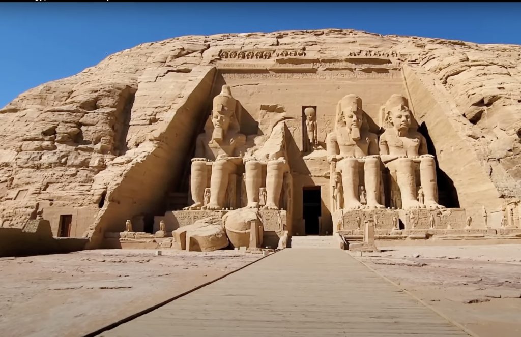 Façade of the Great Temple of Abu Simbel with four colossal seated statues of Pharaoh Ramses II carved into the sandstone cliff, Nubia, Egypt.