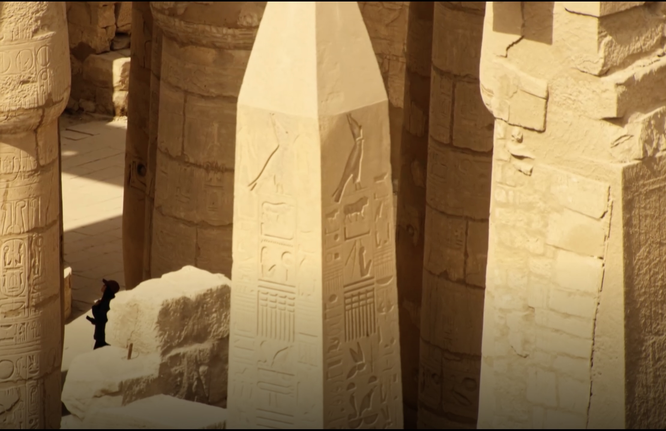 Ancient Egyptian obelisk surrounded by stone columns inside Karnak Temple complex in Luxor Egypt