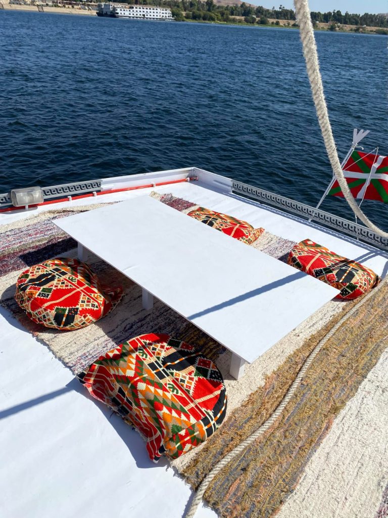 Traditional seating area with cushions on the deck of the felucca Maitea sailing on the Nile near Aswan Egypt