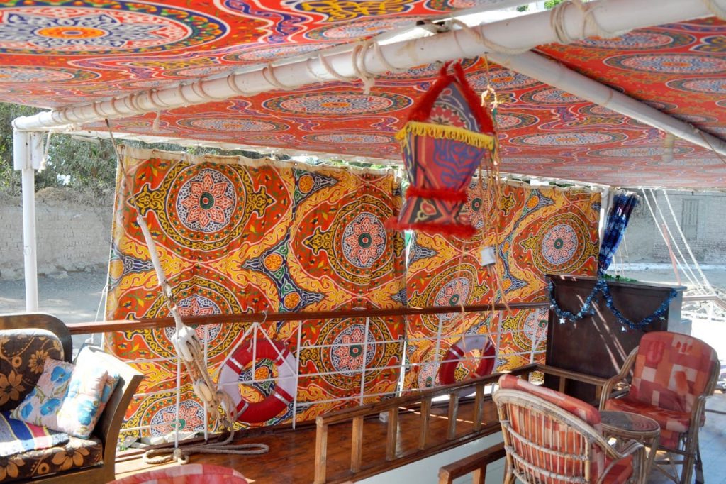 Colorful traditional Egyptian textiles and seating on a dahabiya deck in Egypt
