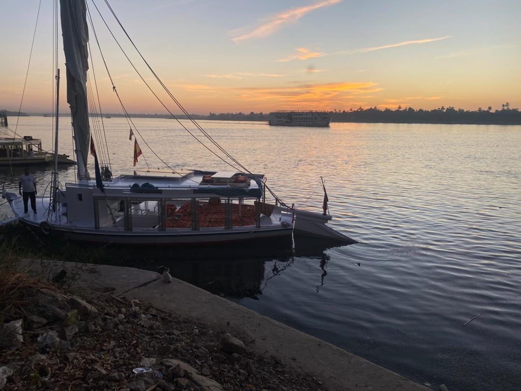 Traditional felucca Maitea moored on the Nile riverbank at sunset near Aswan Egypt