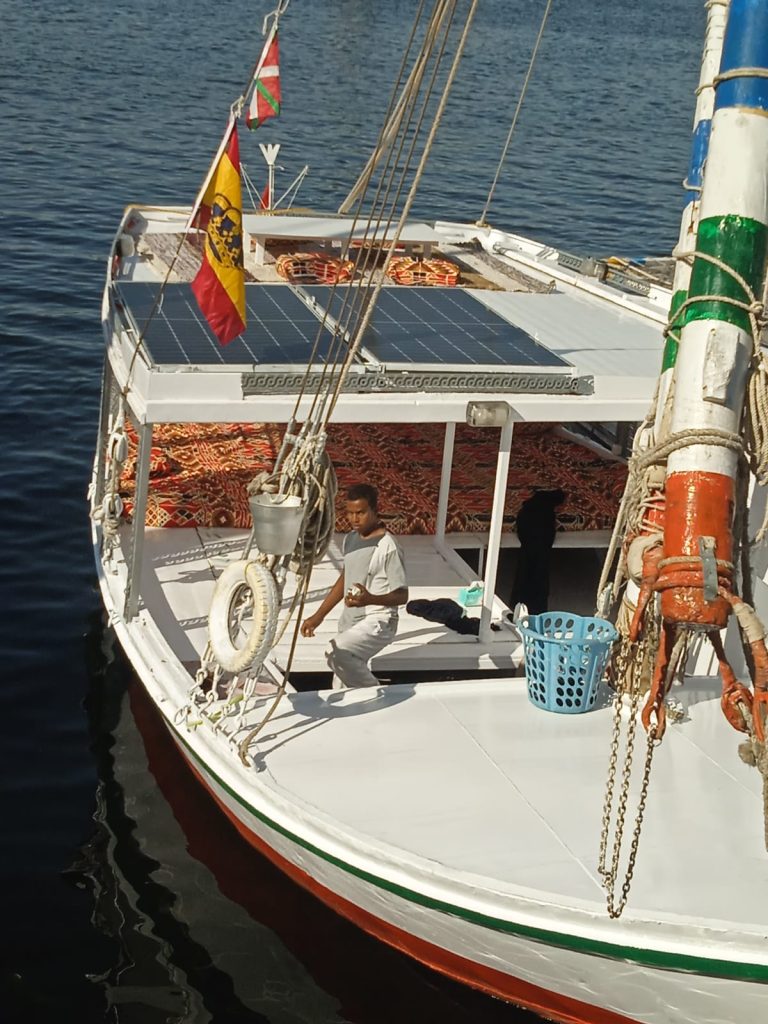 Traditional felucca Maitea deck with solar panels and crew on the Nile near Aswan Egypt