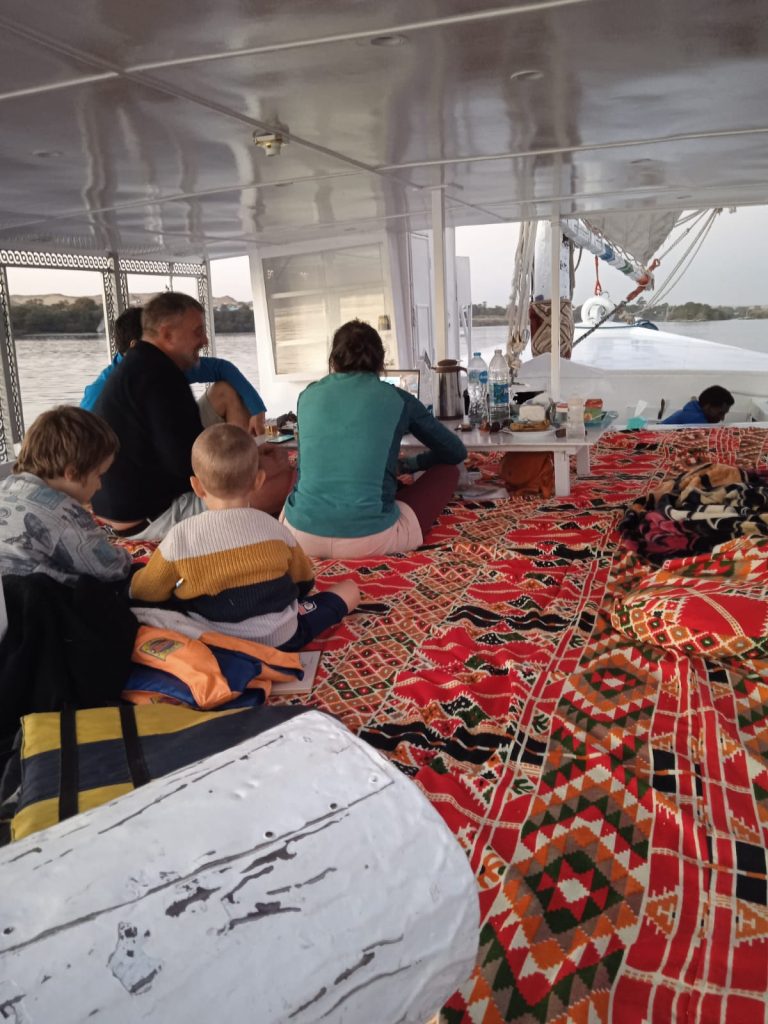 Family from France relaxing on the deck of the felucca Maitea while sailing on the Nile near Aswan Egypt