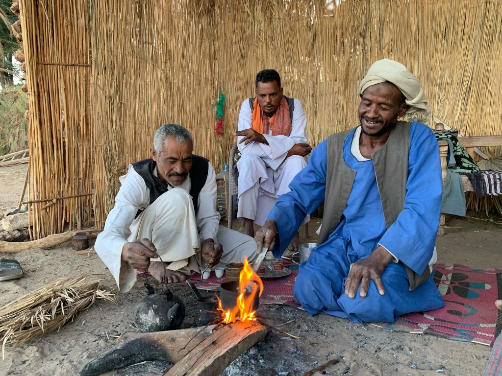 Nubian men preparing traditional coffee in a jabena over a small fire at Al Haman near Gebel El Silsila on the Nile