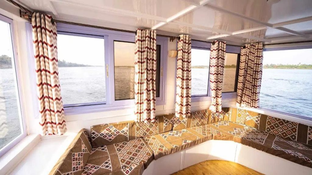Panoramic lounge seating area on Nunet dahabiya with Nile river views in Egypt