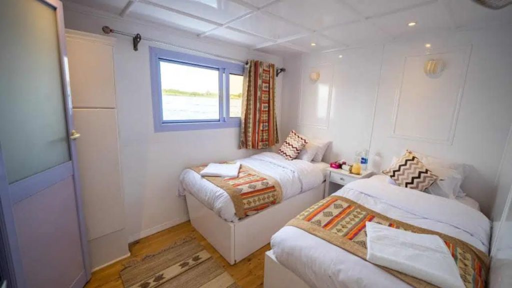 Bright twin cabin on Nunet dahabiya with two beds and Nile river view in Egypt